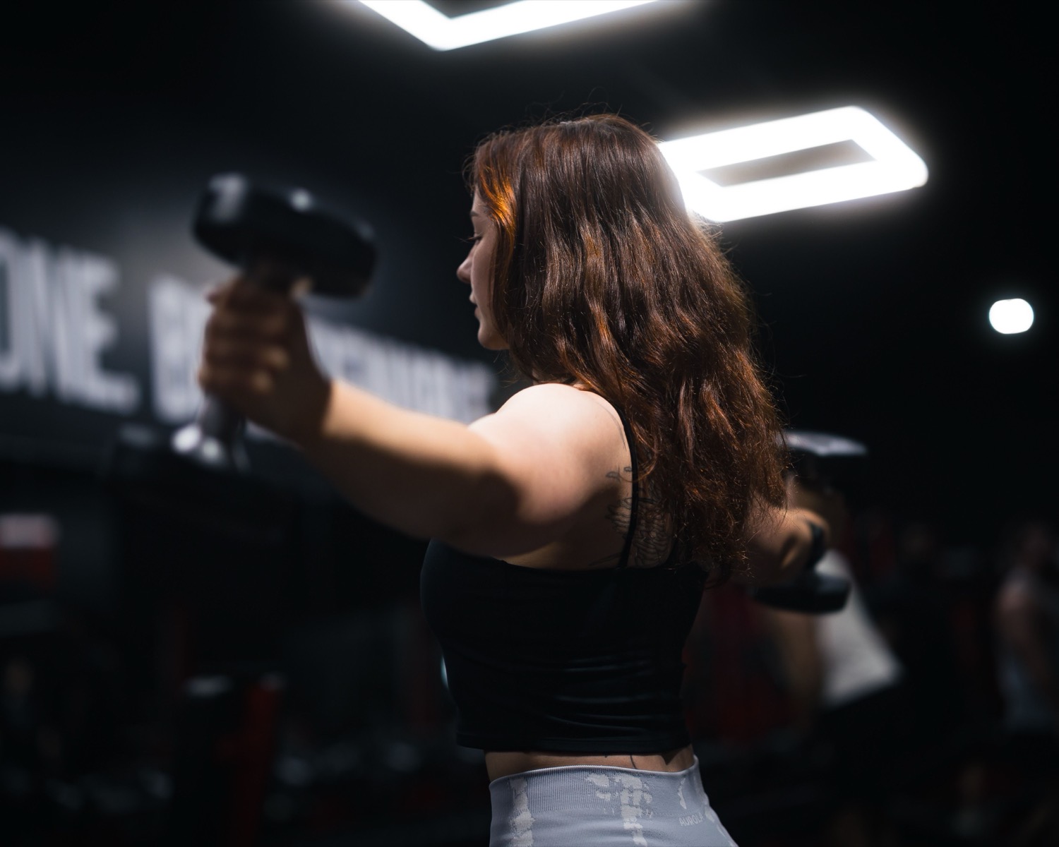 Dumbbell strength training in low, moody light